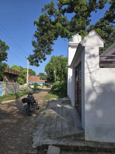 a motorcycle parked next to a white building at Lodhi Home stay in Kākori