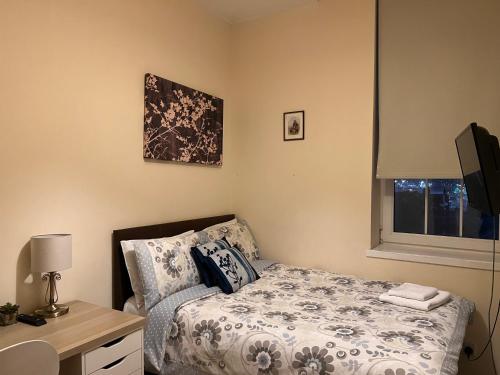 a bedroom with a bed and a desk and a window at Market Street Aberdeen Apartment in Aberdeen