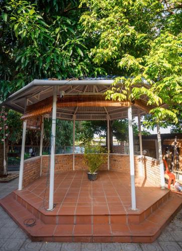 a pavilion with a roof on a brick patio at Lúa homestay in Hue