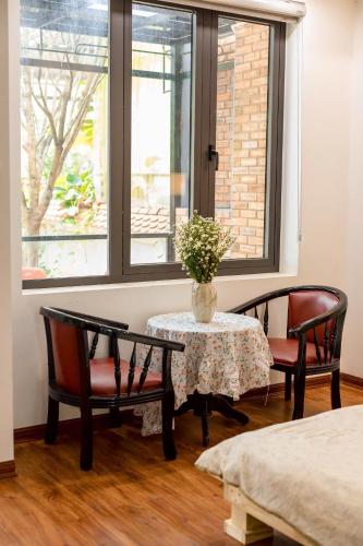 a room with two chairs and a table and a window at Lúa homestay in Hue