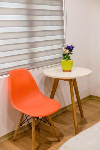 a orange chair and a table with a vase of flowers at Lúa homestay in Hue