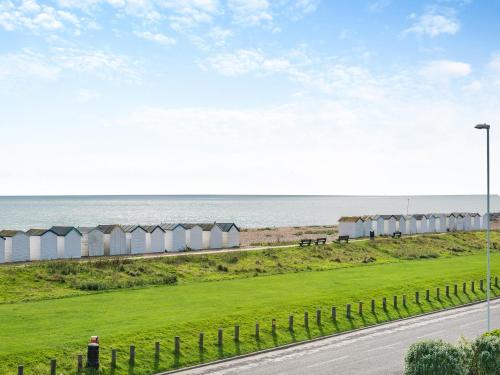 a road next to the ocean with a row of beach huts at Marine Villa in Goring by Sea