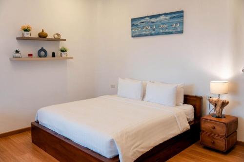 a bedroom with a bed with white sheets at Nontawa Villa Doichang in Ban Huai Khai