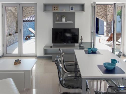 a dining room with a white table and chairs at Apartments Petra in Njivice