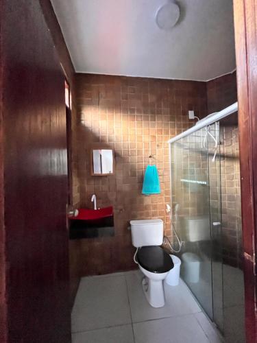 a bathroom with a toilet and a blue lamp at Casa Perto da Praia - Barra de São Miguel in Barra de São Miguel