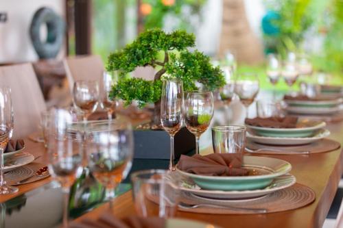 a table with wine glasses and plates on it at Here and Now - Luxury Sea view & Spa Villa in Koh Samui 