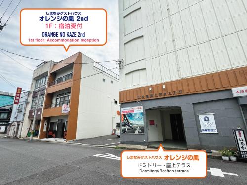 a building with signs on the side of a street at オレンジの風 in Imabari