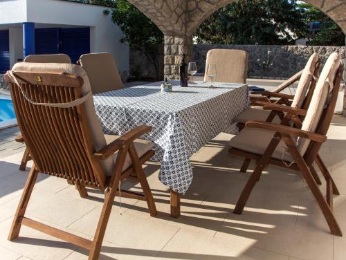 a table and chairs sitting next to a pool at Apartments Petra in Njivice