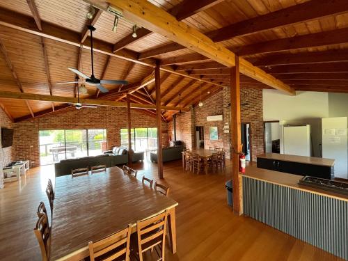 a dining room and living room with a wooden ceiling at Prom Coast Holiday Lodge in Waratah Bay