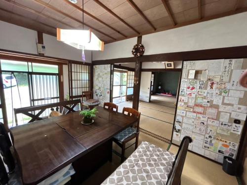 a dining room with a wooden table and chairs at 農家民泊あんちゃん家 in Hama