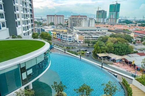 a building with a pool in front of a city at Blue Aesthetic Luxury Seaview 3 min Drive Sunway in Butterworth