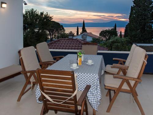 a table and chairs on a patio with a view at Apartments Petra in Njivice