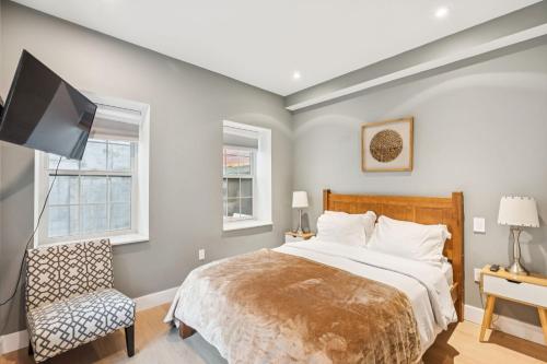 Un dormitorio con una cama, un televisor y una silla. en 24 Stay Rittenhouse, en Filadelfia