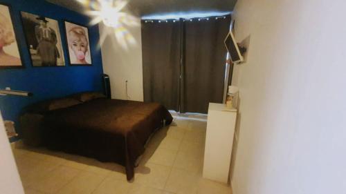 a bedroom with a bed and a blue wall at Casitas in Mexico City
