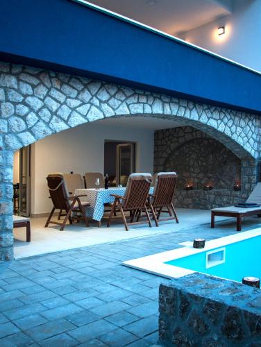 a patio with a table and chairs and a fireplace at Apartments Petra in Njivice