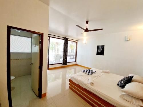 a bedroom with a bed and a ceiling fan at Liberty Guesthouse Maldives in Mahibadhoo