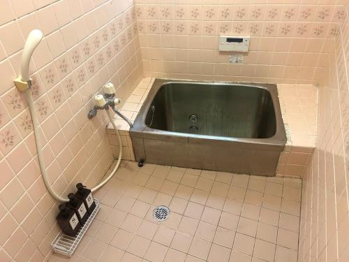a bathroom with a green sink in the corner at 質本宿Shichibonya戸尾町 in Sasebo
