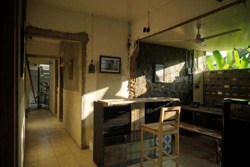 a kitchen with a counter and a chair in it at KOTTA Hostel in Timuran