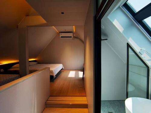 a small attic bedroom with a bed and a window at 华山隐泉禅境 山景观星禅修别墅 Hua Shan Hidden Spring Restore Villa in Huayin