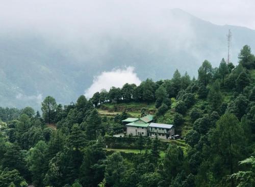 a house on a hill in the middle of a forest at The Alpine Ramgarh in Rāmgarh