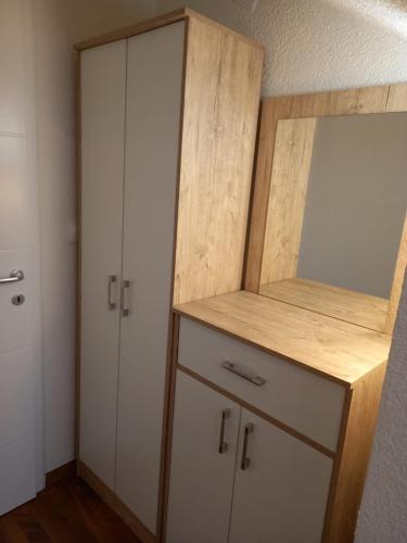 un placard avec une armoire en bois et un miroir dans l'établissement Apartmani Kaić, à Livno