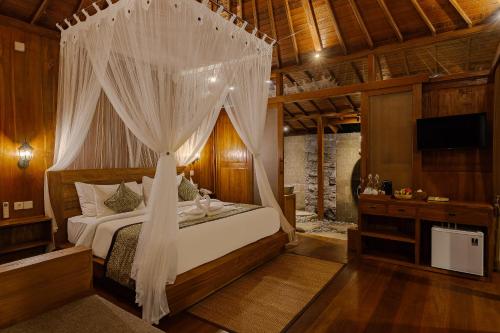 a bedroom with a bed with a canopy at Anandari Ubud Villa in Ubud