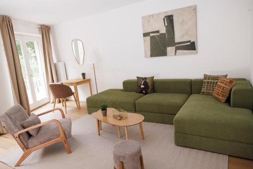 a living room with a green couch and a table at Le 7 KLÉBER in Colmar