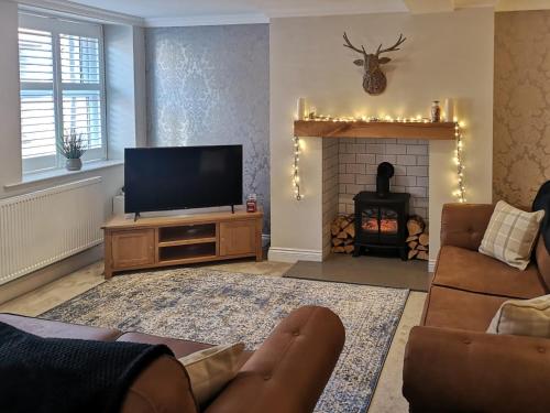 a living room with a television and a fireplace at Castlegate in Penrith