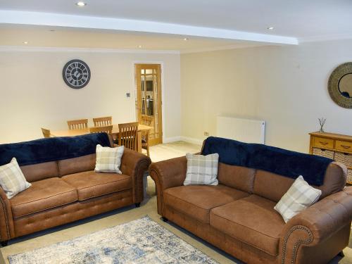 a living room with two leather couches and a table at Castlegate in Penrith