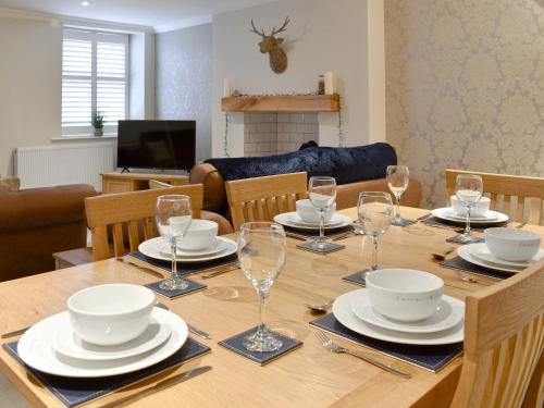 a dining room table with plates and glasses on it at Castlegate in Penrith