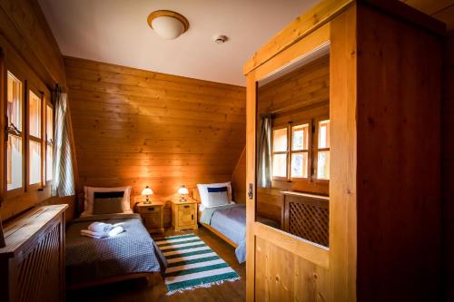 a bedroom with two beds in a wooden room at Hotel****Liptovský dvor in Liptovský Ján