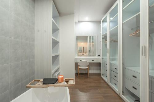 un bagno con mobili bianchi e una vasca da bagno di V227 Private 4BR Pool Villa Beaches & Golf Nearby a Laguna Phuket