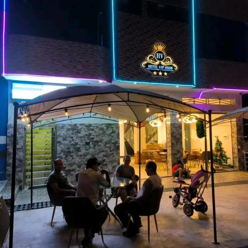 a group of people sitting at a table under an umbrella at HOTEL VIP 46 SSQS in Bagua Grande