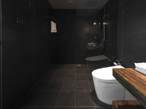 a black bathroom with a toilet and a sink at Yang Liping Xianguo'an Moon Palace Villa, Shuanglang, Dali in Dali Shuanglang