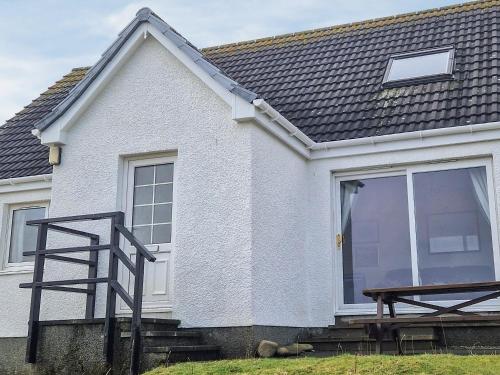 a white house with a window and a staircase at Wavecrest in Staffin