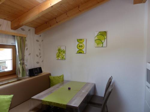 a dining room with a green table and chairs at Haus Hildegard in Neustift im Stubaital
