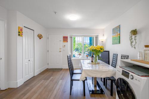 a kitchen and dining room with a table and chairs at 2 Bds suite beautiful Yard near PNE in Vancouver