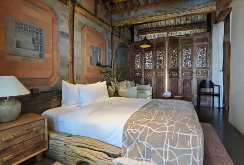 a bedroom with a large bed in a room with wooden walls at Yang Liping Xianguo'an Moon Palace Villa, Shuanglang, Dali in Dali Shuanglang