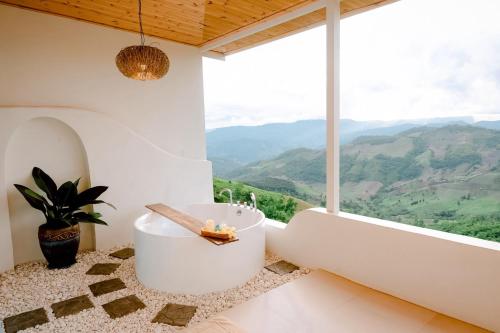 a white bathroom with a tub and a large window at Nontawa Villa Doichang in Ban Huai Khai