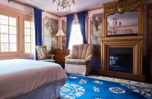 1 dormitorio con 1 cama, chimenea y silla en The Hollywood Homestay, en Los Ángeles