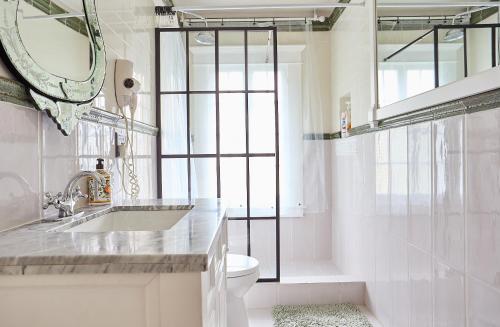Un baño con lavabo, inodoro y espejo. en The Hollywood Homestay, en Los Ángeles