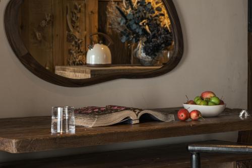 a table with an open book and a bowl of apples at Yang Liping Xianguo'an Moon Palace Villa, Shuanglang, Dali in Dali Shuanglang