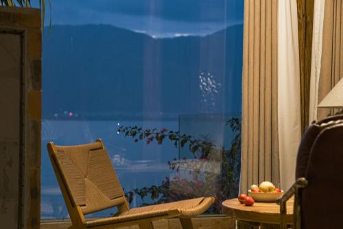 a chair and a bowl of fruit in front of a window at Yang Liping Xianguo'an Moon Palace Villa, Shuanglang, Dali in Dali Shuanglang