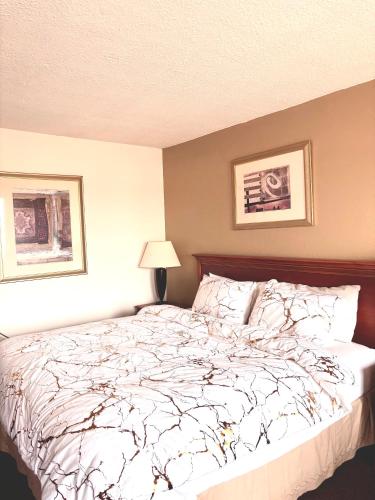 a bedroom with a bed with a white comforter at Dakota Inn in Huron