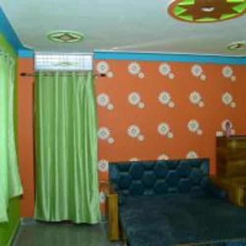 a living room with a couch and green curtains at Phooldei Homestay By StayApart in Devaprayāg
