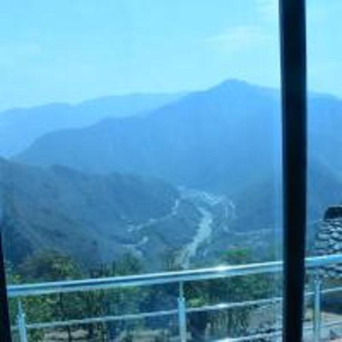 a view of a valley from a window at Phooldei Homestay By StayApart in Devaprayāg