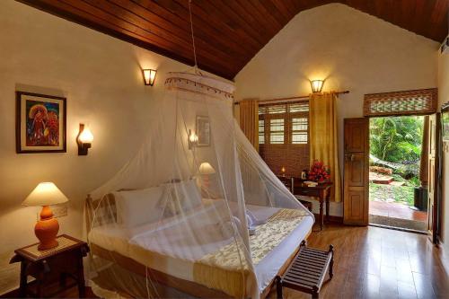 a bedroom with a bed with a mosquito net at Somatheeram Ayurveda village in Kovalam