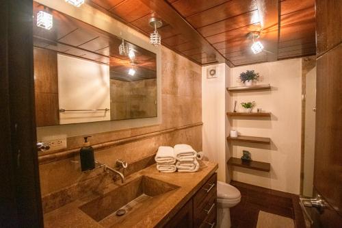 a bathroom with a sink and a toilet and a mirror at Condominio en la marina Pacifika in Los Cerritos