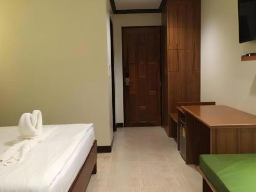a bedroom with a bed and a desk and a door at The Green Hotel in Ko Lipe