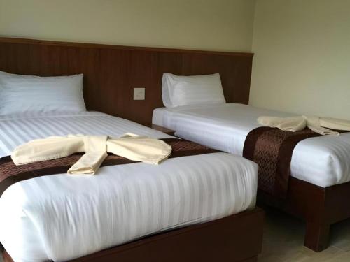two beds in a hotel room with towels on them at The Green Hotel in Ko Lipe